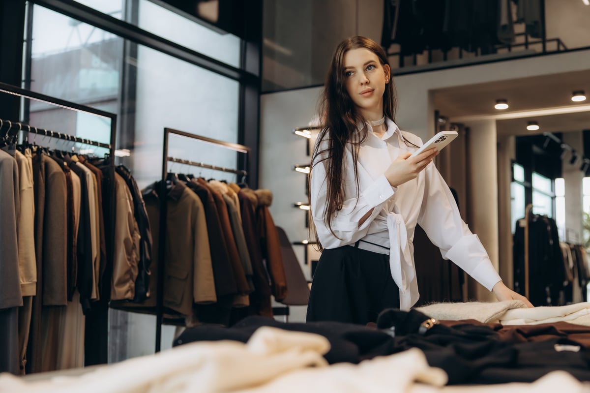 Woman browsing a display of clothing inside a modern boutique